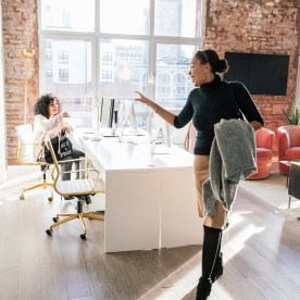 Woman waving goodbye to colleague in office