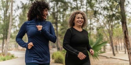 Mother and daughter talking and walking through the public park